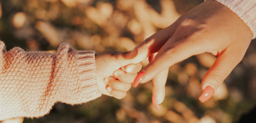 toddler holding mom's hand