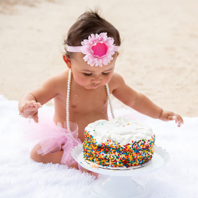 babby with smash cake on beach